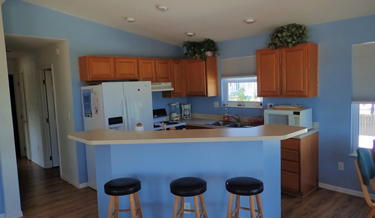The Bay House has a fully-equipped kitchen with a stove, microwave, dishwasher, refrigerator, coffee maker, toaster, and breakfast bar.